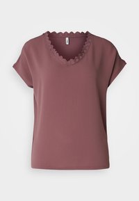 Kortärmad topp i dammig ros, med en scalloperad V-ringning. Tillverkad av lättviktig textil med en avslappnad passform. Inga märkbara mönster eller accenter.