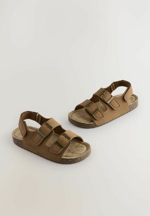 Brune sandaler med to justerbare stropper med gyldne spænder, en blød fodseng og en korklignende struktureret sål.
