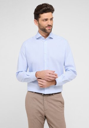 Hellblau gestreiftes Hemd mit Button-Down-Kragen und langen Ärmeln, kombiniert mit beigen Hosen. Glattes Material, taillierte Passform.
