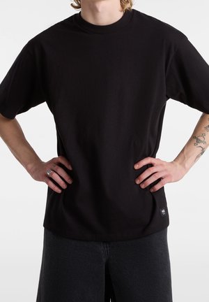 Czarny bawełniany T-shirt z okrągłym dekoltem i krótkimi rękawami. Posiada małą metkę marki po dolnej stronie oraz luźny krój.