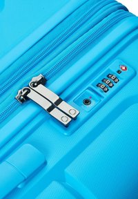 Una maleta rígida azul que cuenta con un doble cierre, cerradura de combinación y un exterior texturizado para mayor durabilidad y agarre.