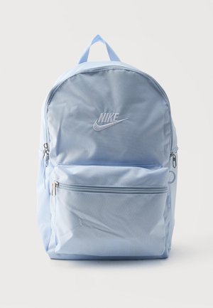 Hele sinine Nike seljakott, millel on peamine lukuga tasku, eesmine lukuga tasku, külgmised võrktaskud ja ülaosas sang.