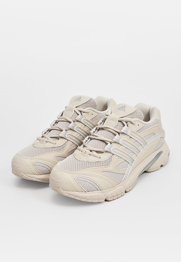 Beige Sport Schuhe mit Obermaterial aus Mesh und synthetischem Material, strukturierten Details, gepolstertem Kragen und Gummisohle. Mit elastischen Schnürsenkeln und Logo-Akzenten.