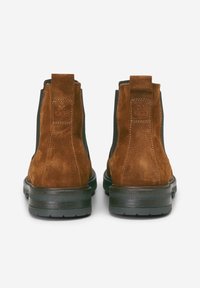 Bottines en daim marron avec des panneaux élastiques sur les côtés et une languette. Dispose d'une semelle en caoutchouc avec une finition texturée. Design simple et moderne.