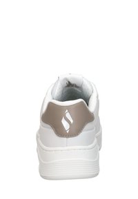 Sneaker bianco con un accento sul tallone color beige, parte superiore in pelle liscia, colletto imbottito e suola in gomma testurizzata. Dettaglio del logo semplice sul tallone.
