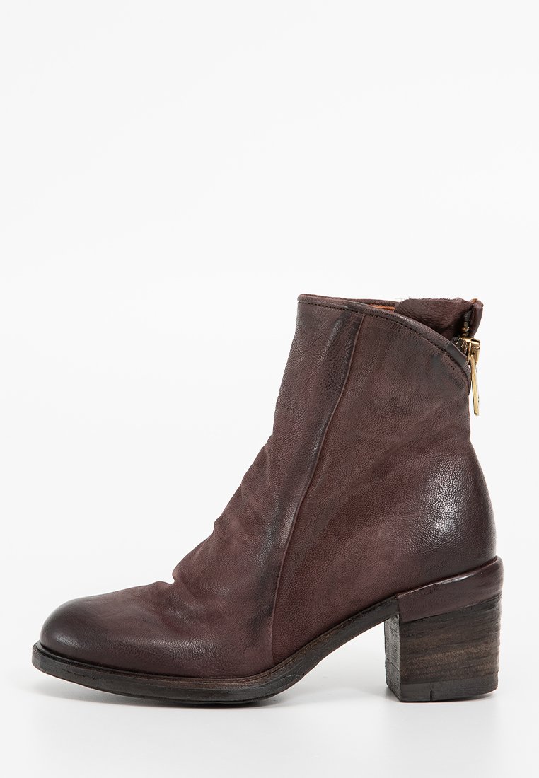 Smeđe kožne gležnjače s opuštenim dizajnom, zaobljenim vrhom i blok petom. Imaju bočni zip i teksturiranu površinu.