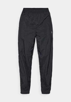 Pantalon de sport noir en tissu léger. Dispose d'une taille élastique et d'un petit logo sur le côté. Design avec jambe fuselée.