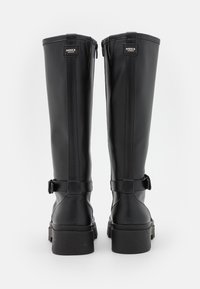 Μαύρες καουτσούκ μπότες έως το γόνατο με λείο φινίρισμα, ρυθμιζόμενους πλευρικούς ιμάντες και παχύ, υφασμένο πέλμα. Διαθέτουν κομψό σχέδιο και κατακόρυφες ραφές.