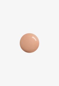 Nail polish in a round drop shape, with a smooth, glossy finish. Color is a light nude beige with a subtle sheen.