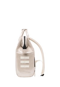 Rucksack mit glänzender, hellbeiger Oberfläche, ausgestattet mit drei horizontalen weißen Riemen, einem oberen Reißverschluss und einem cremefarbenen Schultergurt.