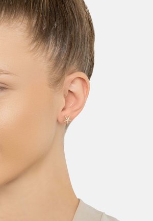 Gold starfish-shaped stud earring with small clear gemstone accents. Smooth finish, compact design, suitable for everyday wear.