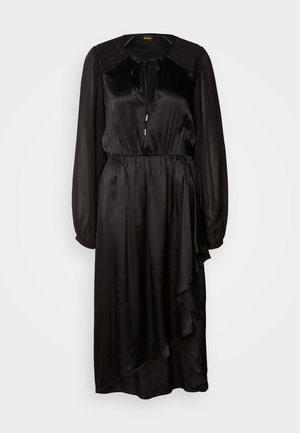 Abito in satin nero con maniche lunghe, scollatura tonda e dettaglio annodato. Presenta una vita arricciata e un orlo asimmetrico con drappeggi.