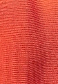 Tela roja con una textura ribeteada suave y diagonal, que presenta un color sólido sin patrones ni acentos. Apariencia uniforme en todo.