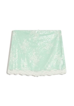 Jasnozielona mini spódniczka z białą koronką w kwiatowy wzór, cekinami, koronkowym brzegiem z falbanką oraz małą kokardką na środku pasa.