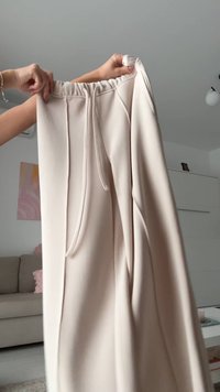 Beige vidde bukser lavet af blødt stof med elastisk linning og snøre. Har forreste læg og lommer på begge sider.