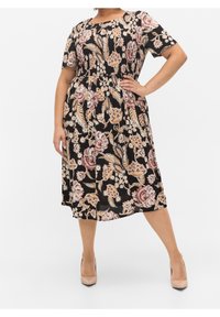 Černé květinové šaty s krátkými rukávy, zdobené velkými růžovými a krémovými květy a listy, s nařaseným pasem a sukní ke kolenům.