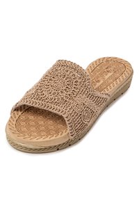 Chancla beige con un diseño trenzado en la parte superior, que presenta patrones en espiral. La plantilla tiene una textura con un patrón de zigzag para mejorar el agarre.