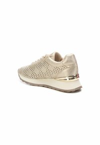 Zapatilla de deporte perforada en dorado con parte superior texturizada, suela blanca acolchada y acento metálico en el talón. Presenta cordones planos y puntera redondeada.