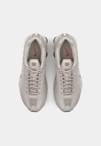 Heledad hallikad heledast hallist värvist, tekstuurse pinnaga, võrguga detailid, silmatorkavad paelad ja punane Nike logo keeles ja küljel.