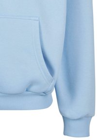 Manche de sweat-shirt bleu clair et poche avant avec bord-côtes aux poignets et à la taille, texture douce du tissu visible en gros plan.