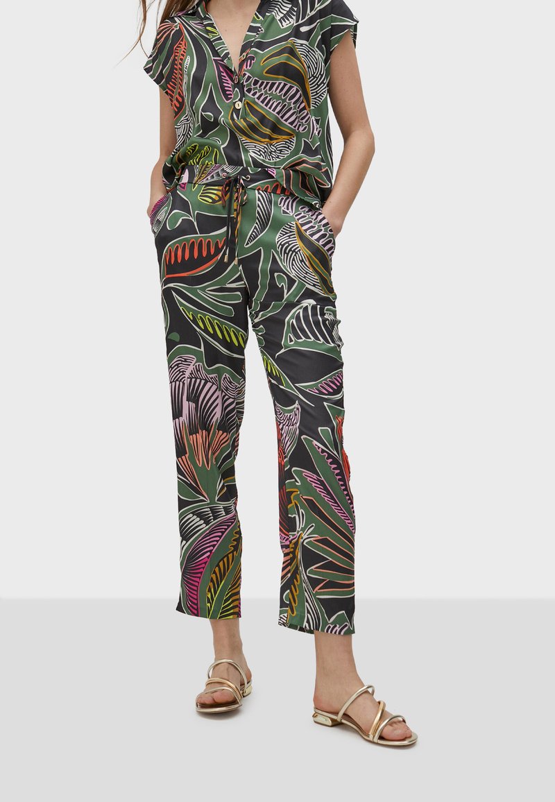 Jumpsuit in satin con maniche corte, caratterizzato da una stampa astratta di foglie in verde, rosa e giallo, con vita regolabile tramite cordoncino e tasche.