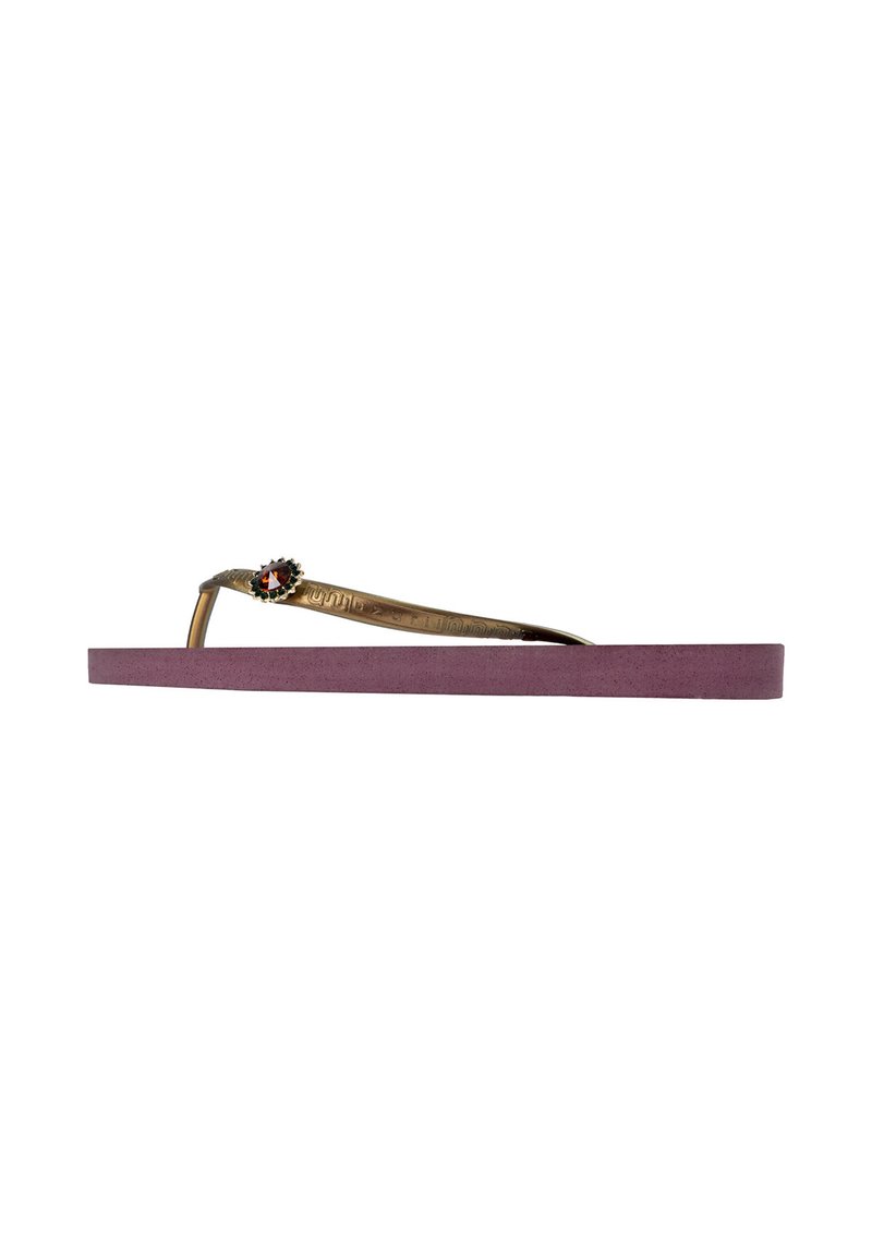 Havaianas met een lavendelkleurige rubberen zool, metallic gouden band met een bloemaccent en een rode edelsteen op het snijpunt. Vlak ontwerp.
