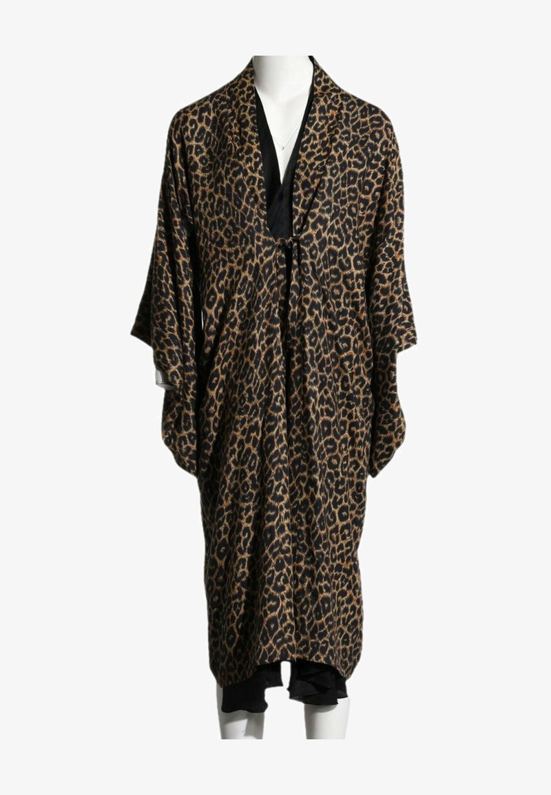 Peignoir ample à imprimé léopard avec larges manches et fermeture à nouer sur une robe noire, sur un mannequin blanc sur fond blanc.