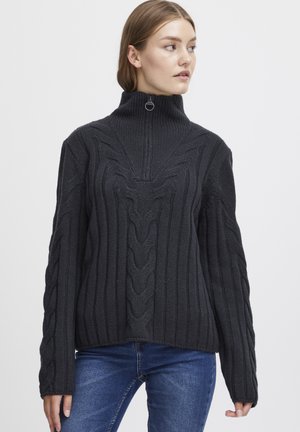 Dark grey knitted sweater with a high collar, featuring cable patterns, and ribbed texture. Includes a short zipper on the neck.