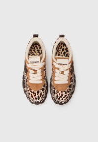 Sneakers feature a leopard print upper, brown suede accents, cream laces, and a textured black rubber sole. Branding displayed on the tongue.