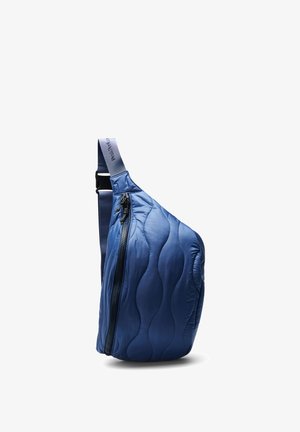 Blue quilted crossbody bag with wavy stitching, black zipper on the front, and adjustable navy strap with brand text.