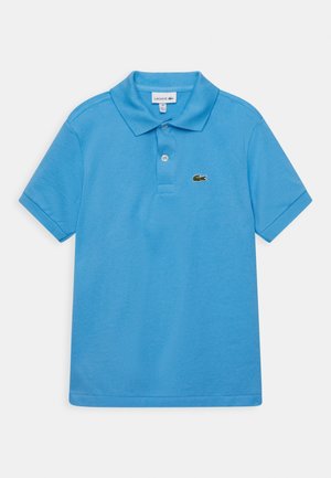 Polo azul hecho de tejido texturizado, con un collar clásico y mangas cortas. Tiene un pequeño logo verde en el lado izquierdo del pecho.