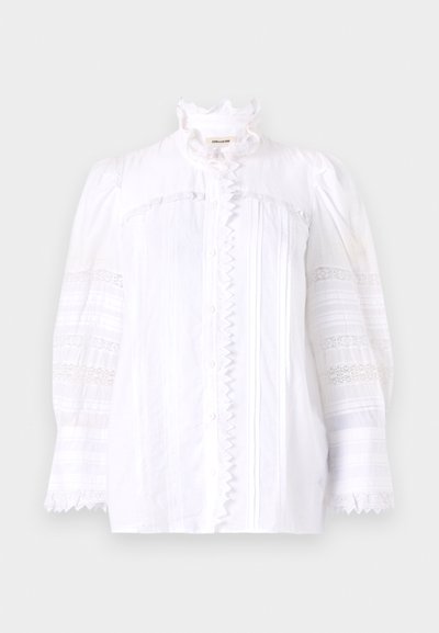 White cotton blouse with ruffled collar, button-down front, and textured paneling. Features puffed sleeves and decorative lace accents.