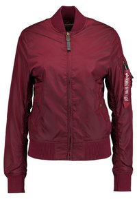 Bordeaux bomberjacka med en slät, glänsande finish. Har en ribbad krage, ärmar och nederkant, samt en ytterficka med dekorativ etikett.