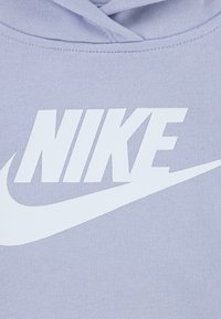 Μωβ βαμβακερό φούτερ με κουκούλα, που διαθέτει ένα έντονο λευκό λογότυπο "NIKE" και το σχεδιασμό με το σήμα swoosh. Το ύφασμα έχει ομαλή υφή και κουκούλα με κορδόνια.