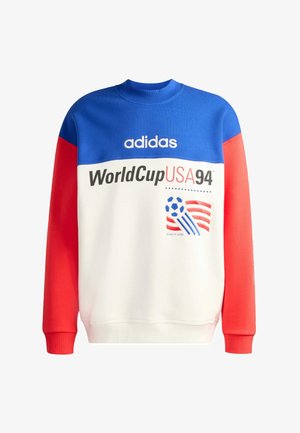 Mikina s modrým horním dílem, bílým tělem, červenými rukávy, logem Adidas, nápisem "WorldCup USA 94" a grafikou fotbalového míče s červenými a bílými pruhy.