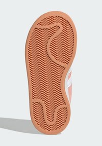 Rubber shoe sole in peach with a wave pattern. Features a smooth, textured surface and curved outlines. Overall, a flat, wide shape.