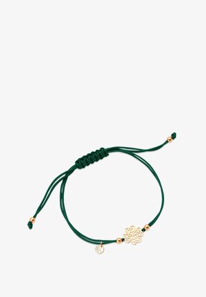 Zielona bransoletka z cordu z złotym charms'em w kształcie kwiatu oraz małym złotym dyskiem, z węzłowymi akcentami i regulowanym zapięciem typu sliding.