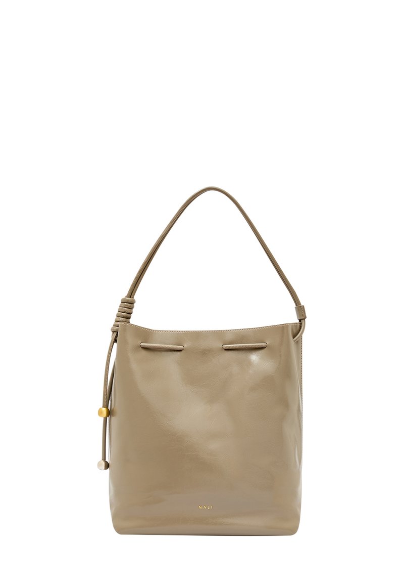 Beżowa skórzana torba typu bucket o gładkiej fakturze, regulowanym pasku na ramię, podwójnych sznurkowych zapięciach oraz małej ozdobnej koralikach.
