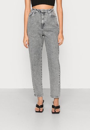 Jeans de cintura alta, com pernas retas, em denim cinza desbotado. Apresenta cinco bolsos e fecho com botão. Combinados com sandálias pretas.