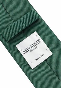 Vihreä solmio, jossa on uritettu pinta. Sisältää valkoisen tarran, jossa lukee "JOHN HENRIC SWEDEN" ja "Made In Italy."