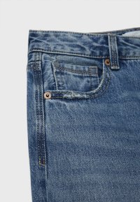 Farkkuhousut, jotka ovat vaaleansiniset, suora leikkaus, viiden taskun malli kirjailu- ja kuparinen niitti edessä.