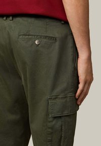Olijfgroene cargobroek gemaakt van duurzaam katoen, met een achterzak voorzien van een knoopdetail en zijcargozakken voor extra opbergruimte.