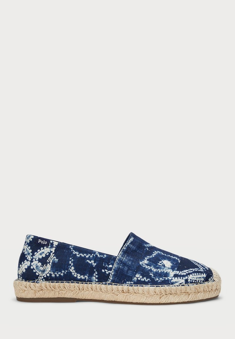 Espadrille de tela azul marino con patrones intrincados en blanco, con suela de cuerda de espadrille y diseño deslizante. Marcado con la etiqueta "Polo".