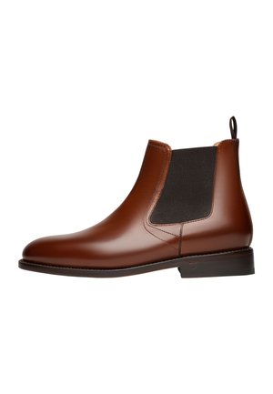 Bottines Chelsea en cuir marron avec des panneaux latéraux élastiques, bout arrondi et un petit talon carré. Texture lisse et détails de couture minimaux.