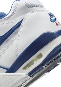 Zapatillas blancas y azules con materiales de cuero y malla, presentan amortiguación de aire visible, costuras detalladas y un logotipo bordado.