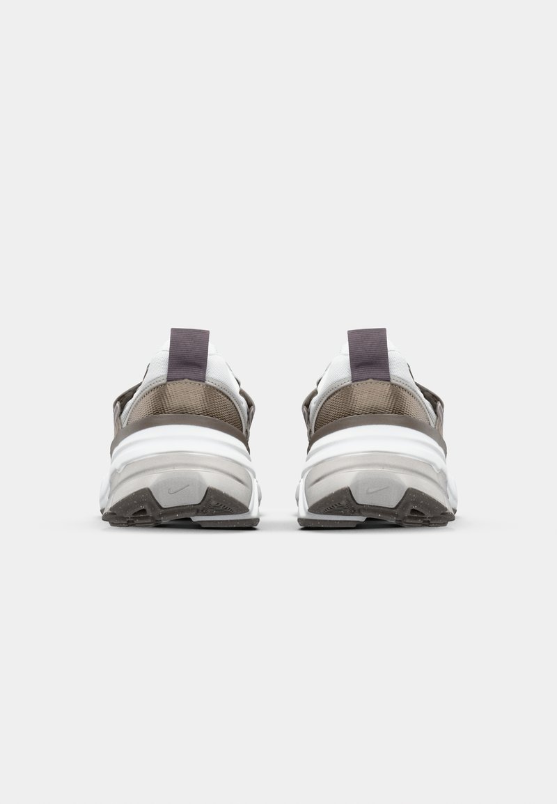 Zapatillas blancas y marrones con material de malla y cuero, que cuentan con una suela blanca gruesa, acentos texturizados y lengüetas en los talones.