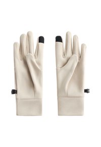 Jasnobeżowe rękawiczki o gładkiej teksturze, z czarnymi końcówkami palców i regulowanymi paskami na nadgarstkach dla pewnego dopasowania.