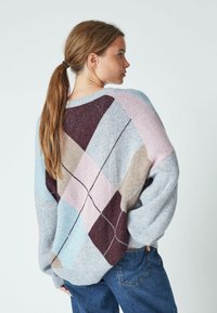 Maglione chunky lavorato a maglia con un motivo geografico in tonalità di blu, rosa, marrone e grigio. Presenta una vestibilità comoda e una texture leggera.