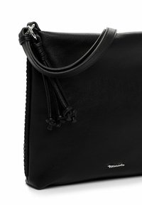 Borsa a mano in pelle nera con texture liscia, dotata di una singola tracolla, dettagli con nappine e un logo argentato.