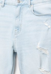 Lyseblå denim jeans med lige skæring, forlommer og slidte sektioner med frynset kant. Glat tekstur med synlige sømme.